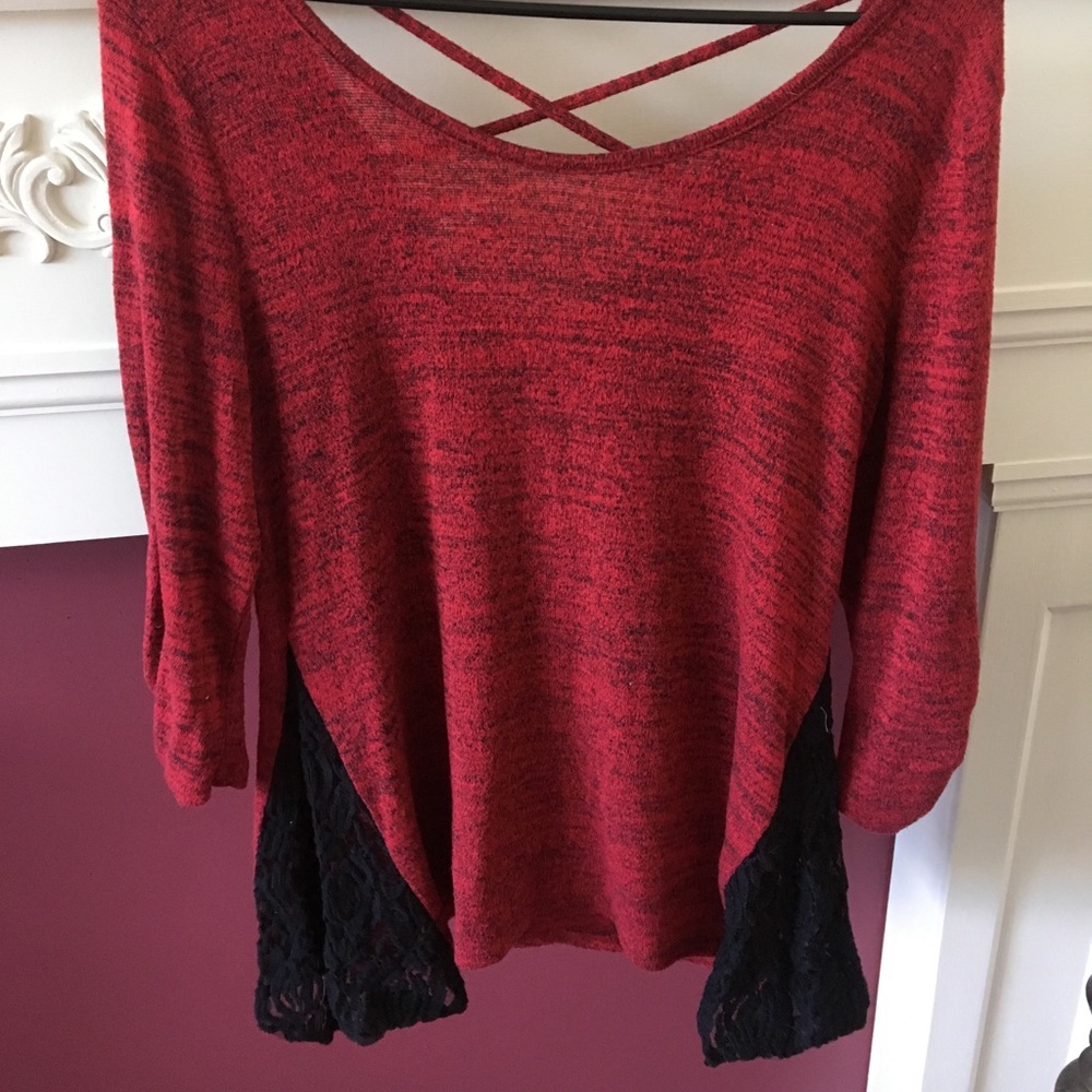 Red sweater with lace accent on the sides.